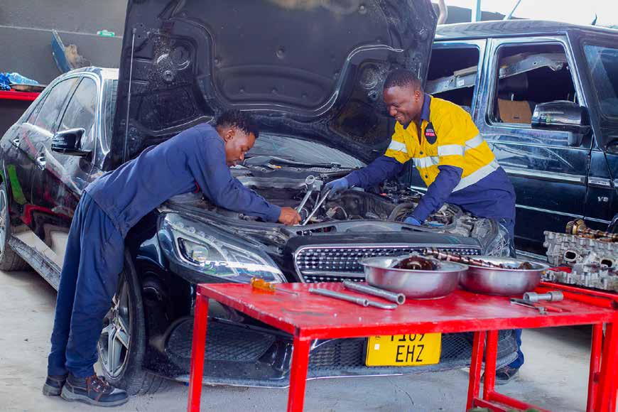 Technicians working on a vehicle engine